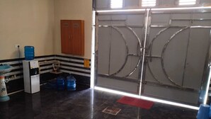 A kitchen with a refrigerator, water dispenser, and blue water jugs.