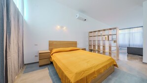 Een moderne slaapkamer met een houten bed, nachtkastjes, een inbouwkast en een groot raam met gordijnen.