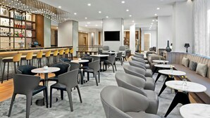 A modern hotel lobby with a bar area, seating arrangements, and a large screen. - AC Hotels by Marriott Sacramento Folsom (Folsom)