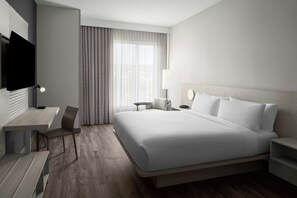 A hotel room with a large bed, a desk, a chair, a TV, and a window with curtains. - AC Hotels by Marriott Sacramento Folsom (Folsom)