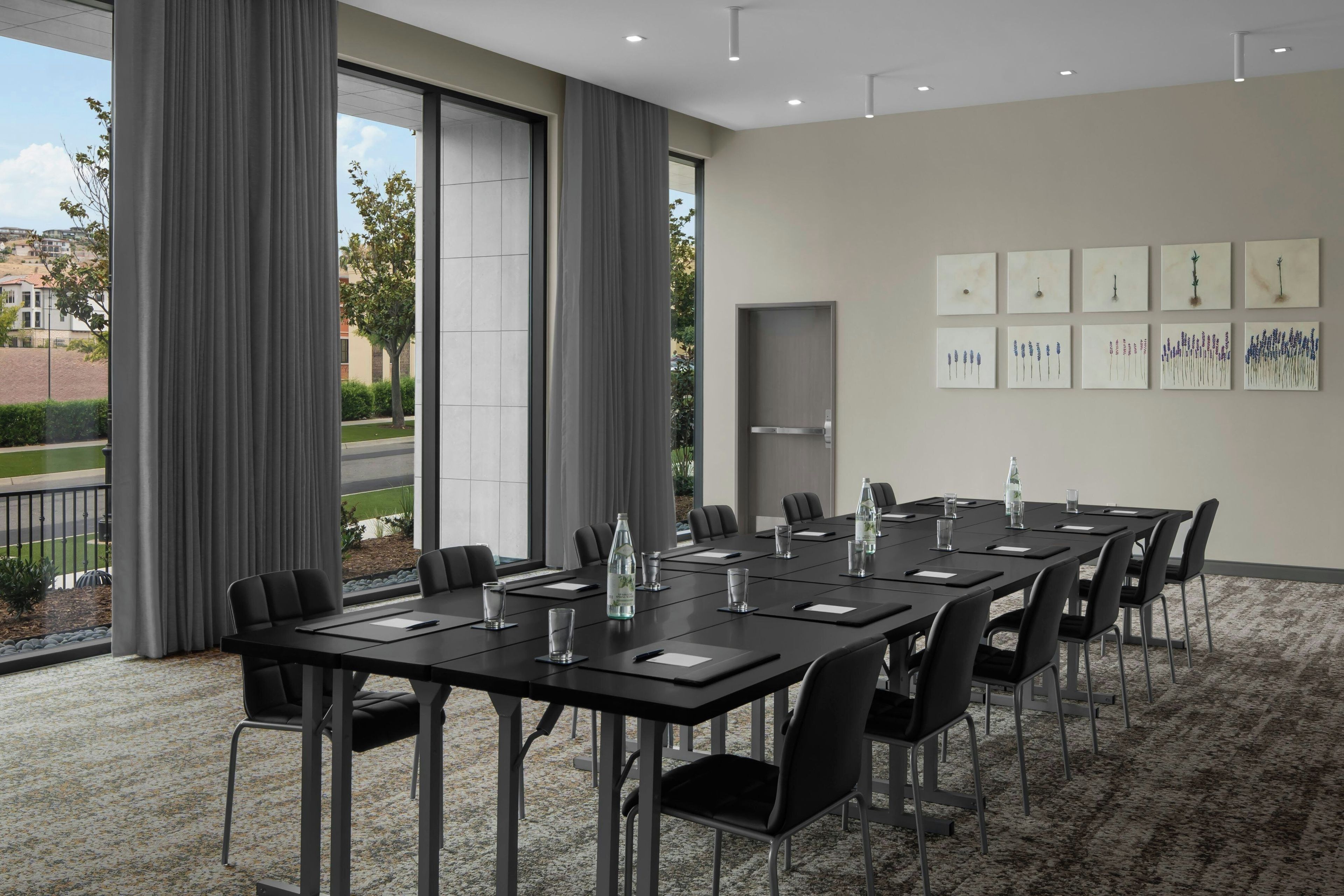 A conference room with a long table, chairs, and a water bottle on the table.