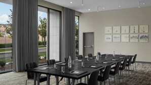 A conference room with a long table, chairs, and a water bottle on the table.