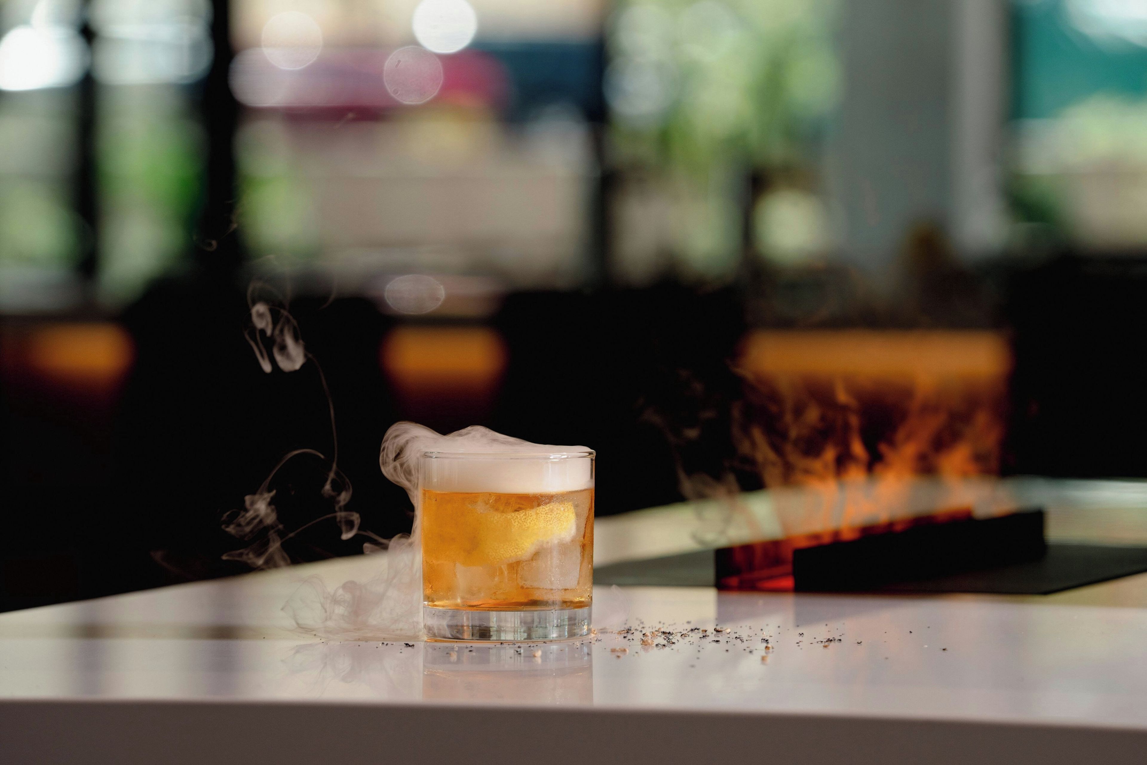 Un bicchiere di birra con schiuma su un bancone del bar.