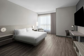 A modern hotel room with a large bed, a desk, a chair, and a TV. - AC Hotels by Marriott Sacramento Folsom (Folsom)