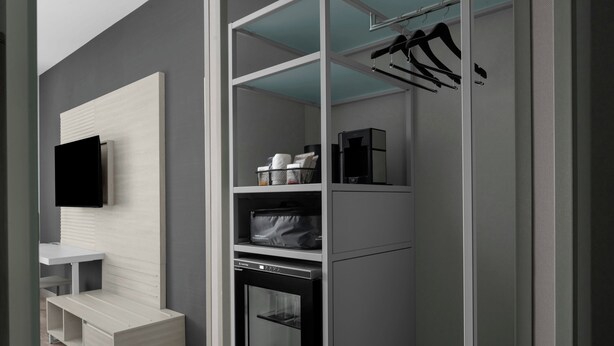 A modern bathroom with a built-in shower, a vanity with a mirror, and a towel rack.