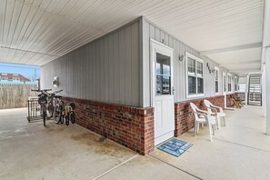 Un espacio al aire libre cubierto con pared de ladrillo, una puerta y un aparcamiento para bicicletas.