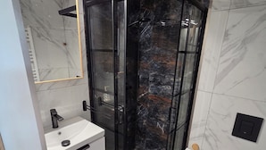 A modern bathroom with a glass-enclosed shower, a white sink, and a toilet. - Modern studio near Krakow Old Town + WiFi (Kraków)