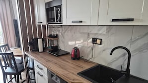 A modern kitchen with a dishwasher, a kettle, a coffee machine, and a microwave. - Modern studio near Krakow Old Town + WiFi (Kraków)