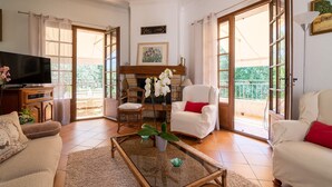 A spacious living room with a fireplace, a television, and a balcony with a view. - Provencial Villa in Vence with Private Swimming Pool (Vence)
