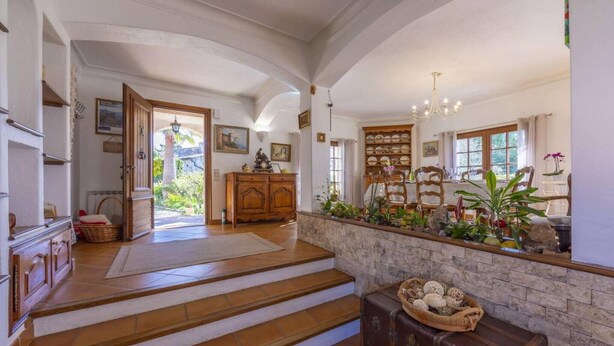 A spacious hallway with a staircase leading to a dining area, wooden cabinets, and a stone wall with plants. - Provencial Villa in Vence with Private Swimming Pool (Vence)