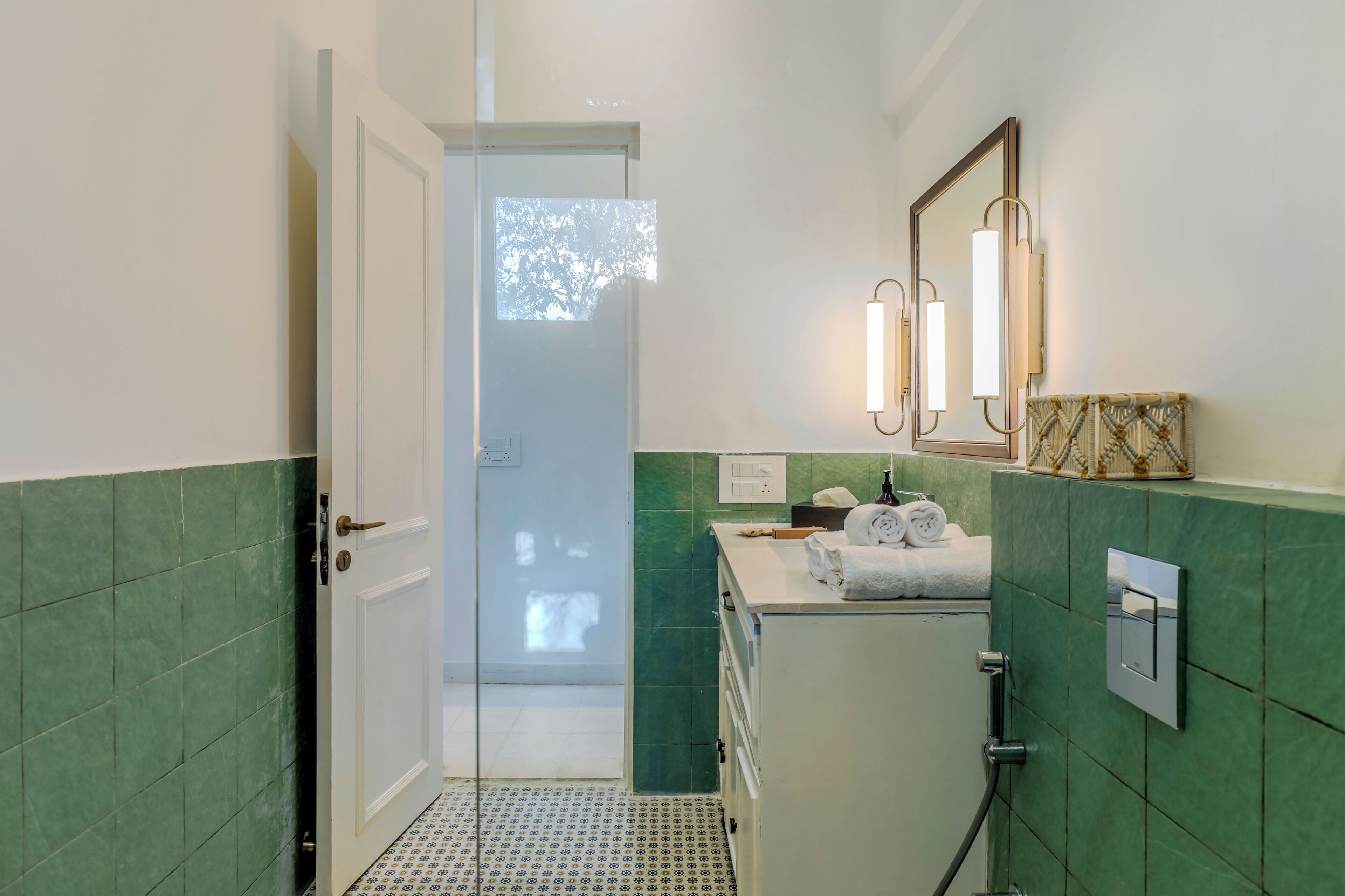 A bathroom with a shower, a sink with a mirror, and a towel rack.
