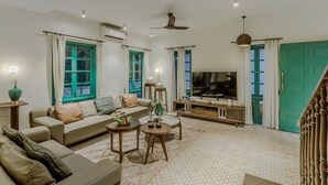 Un salón con sofá, mesa de centro, televisor y adornos.