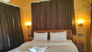 A neatly made bed with white linens and pillows, a wooden headboard, and two wall-mounted light fixtures. - Thorn Kitchen &Hideaways (Hoshiarpur)