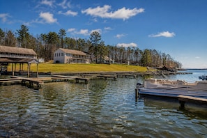 A lakeside property with a dock, a house, and a grassy area.