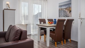A dining area with a table, chairs, a pitcher, and a fruit bowl. - Bahnhofstraße 10 - Apartment 3 - Holiday apartment in Zingst with balcony near the beach (Zingst)