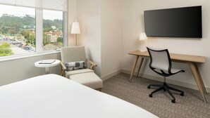 A hotel room with a bed, a desk, a chair, a TV, and a view of a cityscape. - Element by Marriott San Diego Mission Valley (San Diego)
