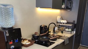 A compact kitchen with a coffee machine, a water dispenser, a microwave, and a small sink. - Welcome to your modern, peaceful escape just minutes from the airport &CBD (Nairobi)