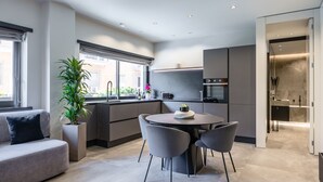 A modern kitchen with a dining area, built-in appliances, and a large window. - Santopaolo Boutique Apartment  (Naples)