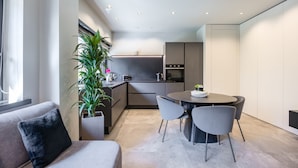 A modern kitchen with a dining area, a sofa, and a potted plant. - Santopaolo Boutique Apartment  (Naples)