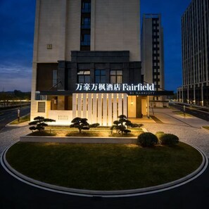 A modern hotel with a prominent sign, a well-lit entrance, and a landscaped garden area. - Fairfield BY Marriott Ningde Xiapu (Ningde)