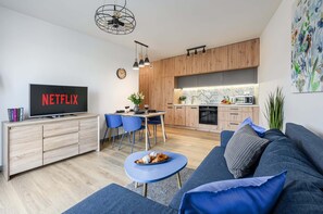 A modern living room with a television, sofa, and dining area. - Lumina apart near Centrum Praskie Koneser (New apartment)