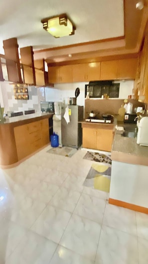 Una cocina moderna con armarios de madera, una isla central y piso de baldosas.