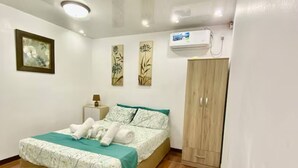 Un dormitorio con cama, armario, mesita de noche y decoración en la pared.