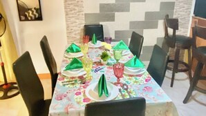 Un comedor con una mesa larga, sillas y un muro decorativo.