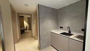 A modern kitchen with grey tiles, a sink, and a countertop. - Lamar Park Hotel Al Olaya (Tabuk)