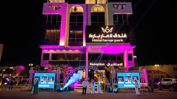 A hotel with a reception area, a sign in Arabic, and a stage with lights. - Lamar Park Hotel Al Olaya (Tabuk)