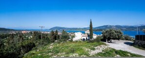 A coastal landscape with a church, a clear blue sky, and a view of the sea. - Asmira Apartments (Lefkada)