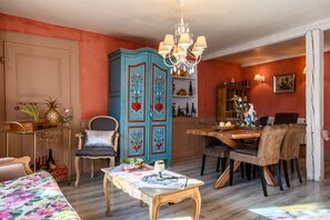 Comedor con mesa de madera, sillas y candelabro.