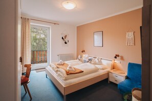 A bedroom with a bed, a blue sofa, a chair, and a window with curtains. - Room 'Ba Ins' with Mountain View, Shared Pool and Wi-Fi (Naturno)