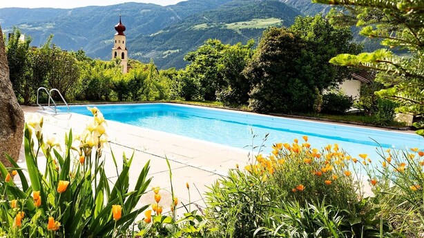 A swimming pool with a view of a church and mountains. - Apartment 'Jack Daniels' with Mountain View, Shared Pool and Wi-Fi (Naturno)