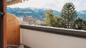 A balcony with a view of snow-capped mountains and a pine tree. - Apartment 'Jack Daniels' with Mountain View, Shared Pool and Wi-Fi (Naturno)