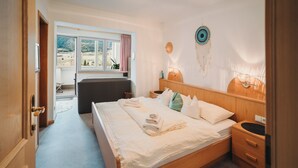 Ein Schlafzimmer mit einem Bett, einem Nachttisch und einem Fenster mit Vorhängen.