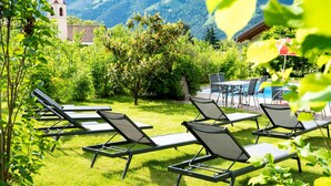 A garden with sun loungers, a pool, and a mountain view. - Room 'Garni Unterweggütl Love' with Mountain View, Shared Pool and Wi-Fi (Naturno)