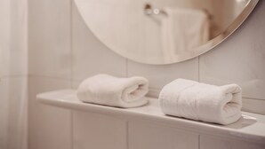 A bathroom with a white toilet, a round mirror, and two neatly folded white towels on the edge of the toilet. - Room 'Tiroler' with Mountain View, Shared Pool and Wi-Fi (Naturno)