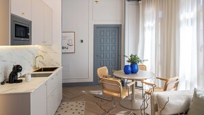 A modern kitchen with a built-in microwave, a sink, and a dining area with a round table and chairs.