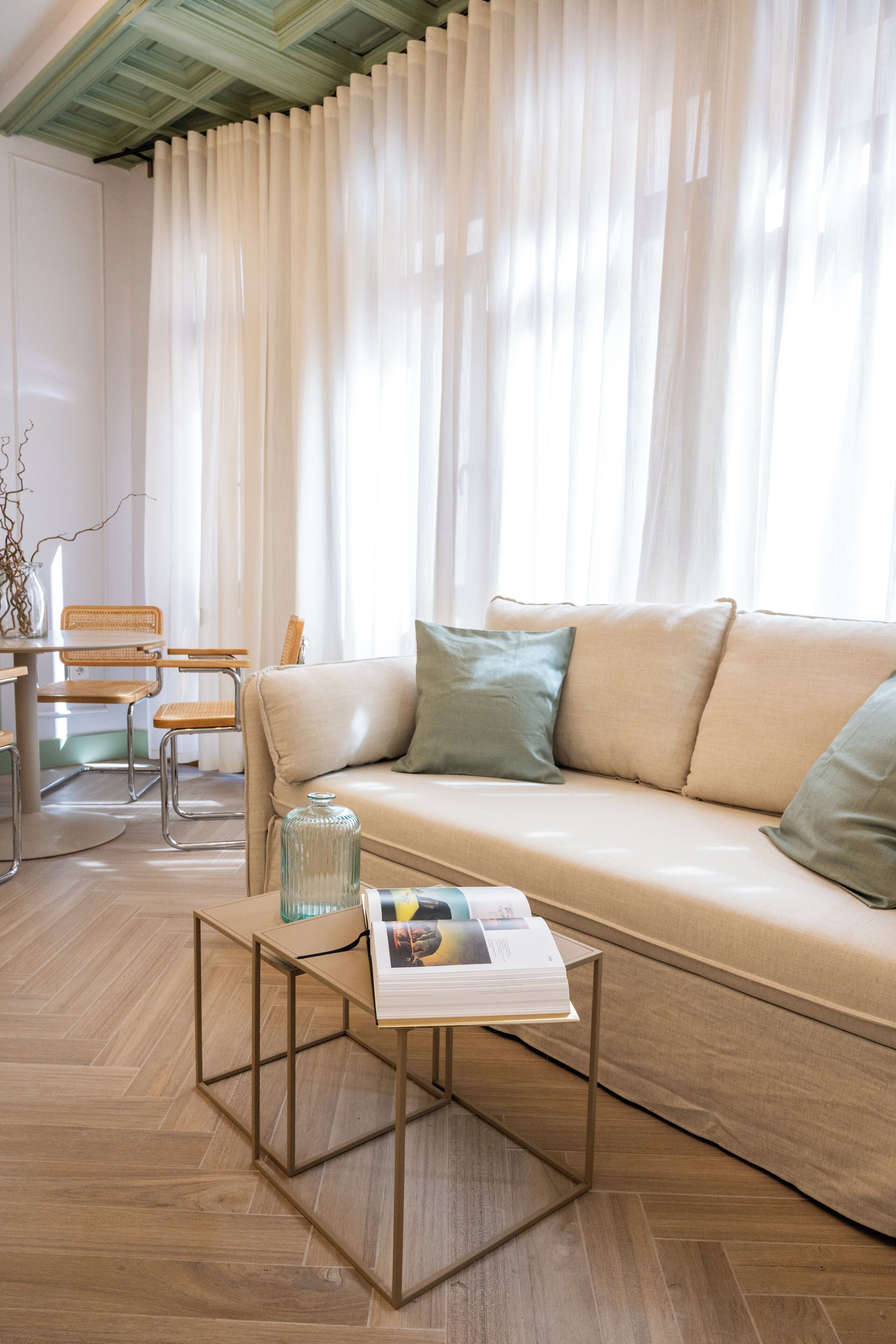 Een woonkamer met een bank, een salontafel, en een eethoek met stoelen en een tafel.