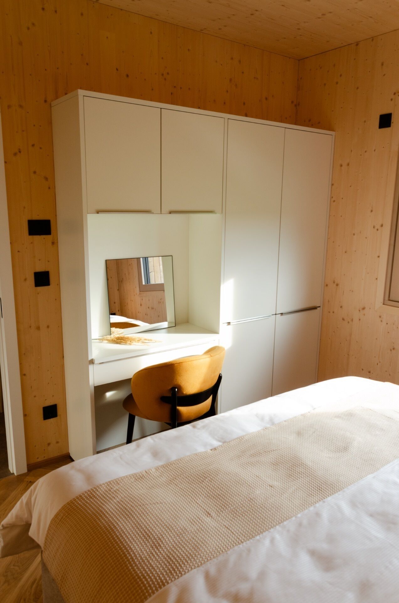 Een slaapkamer met een bed, een bureau en een stoel.