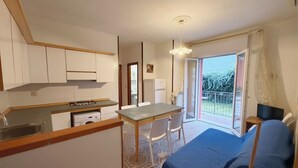 Cocina compacta con comedor, cama y balcón con vistas.