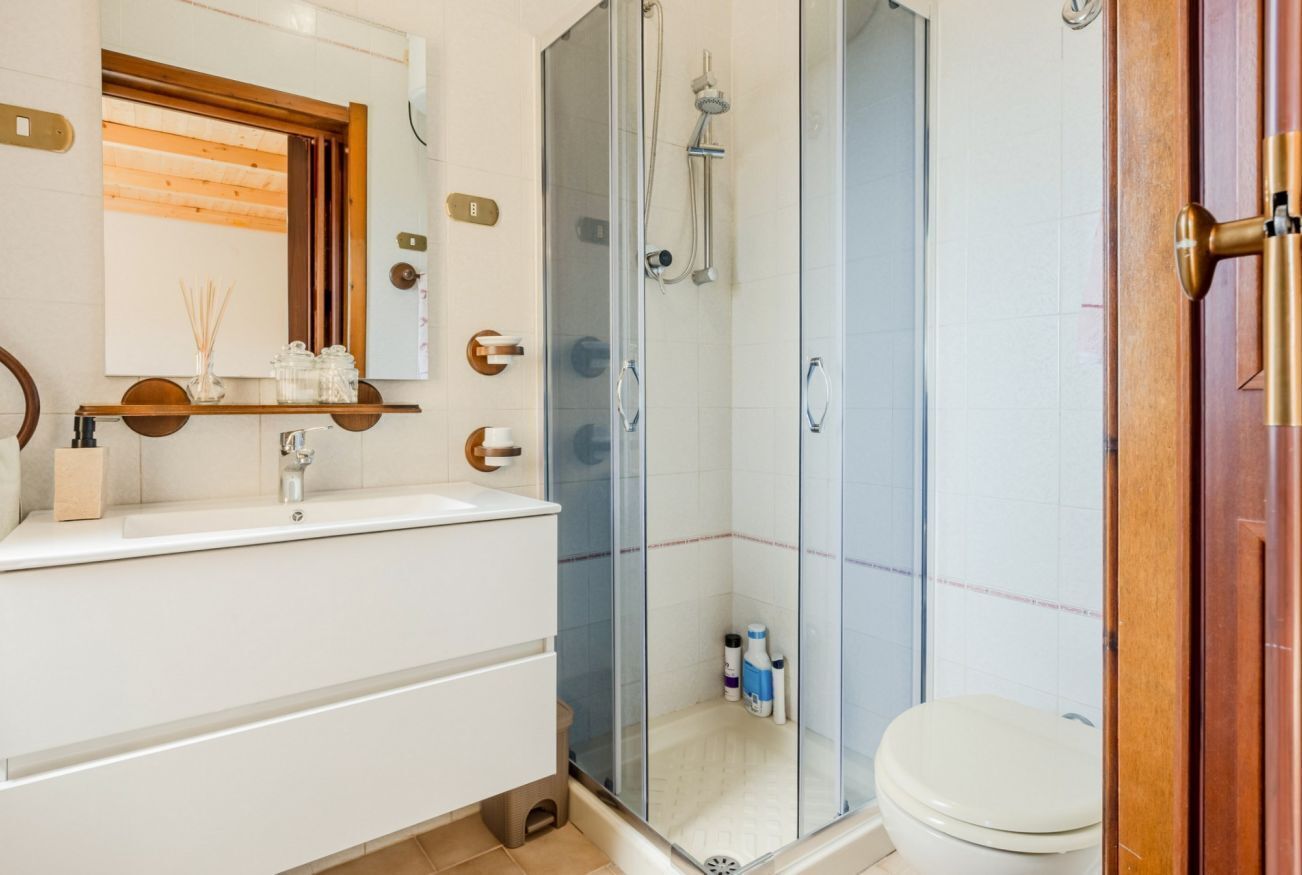 Une salle de bain moderne avec une douche à parois de verre, un lavabo blanc et des toilettes.