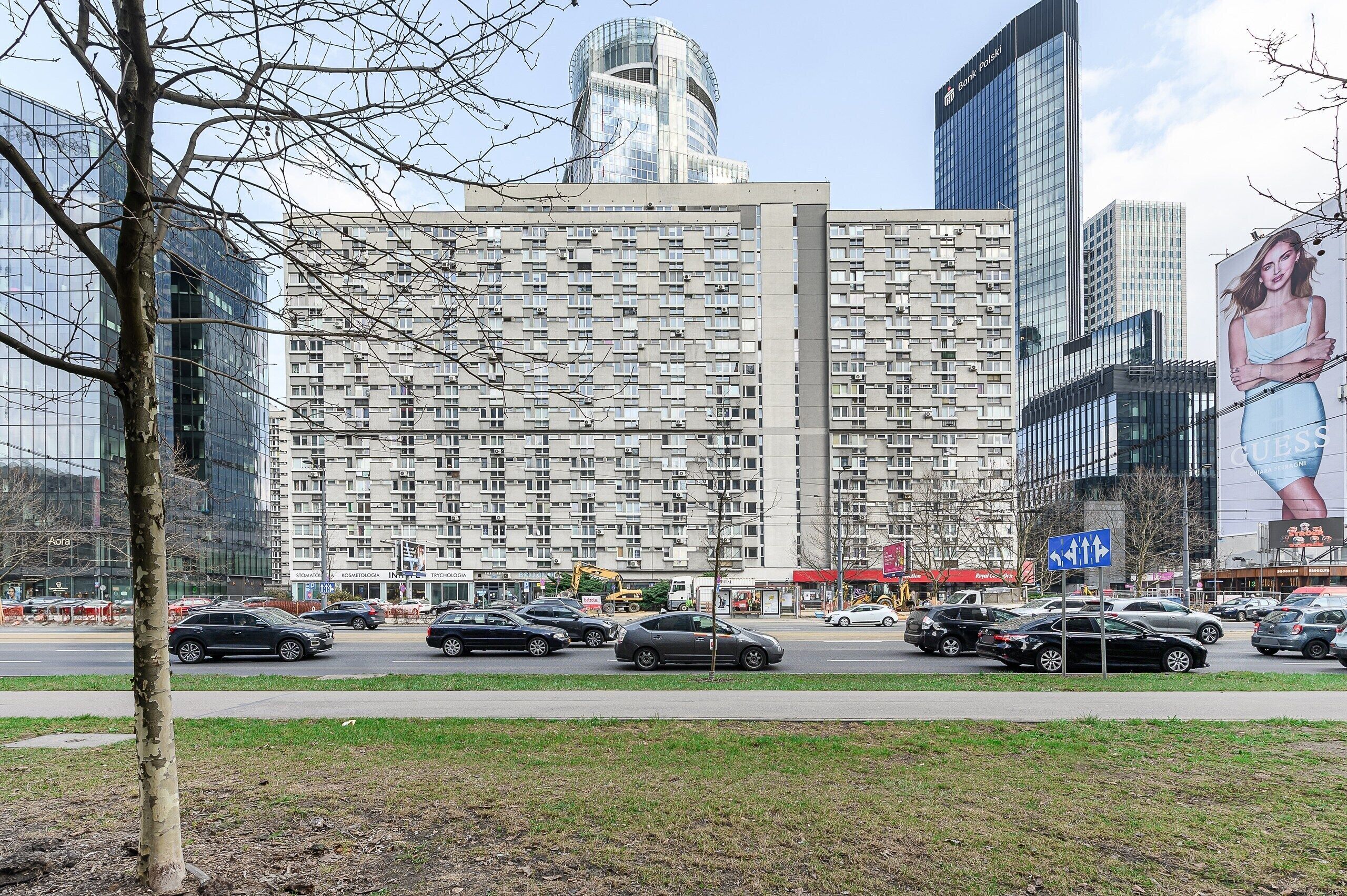 A multi-story building with a modern architectural design, featuring a mix of glass and concrete facades.