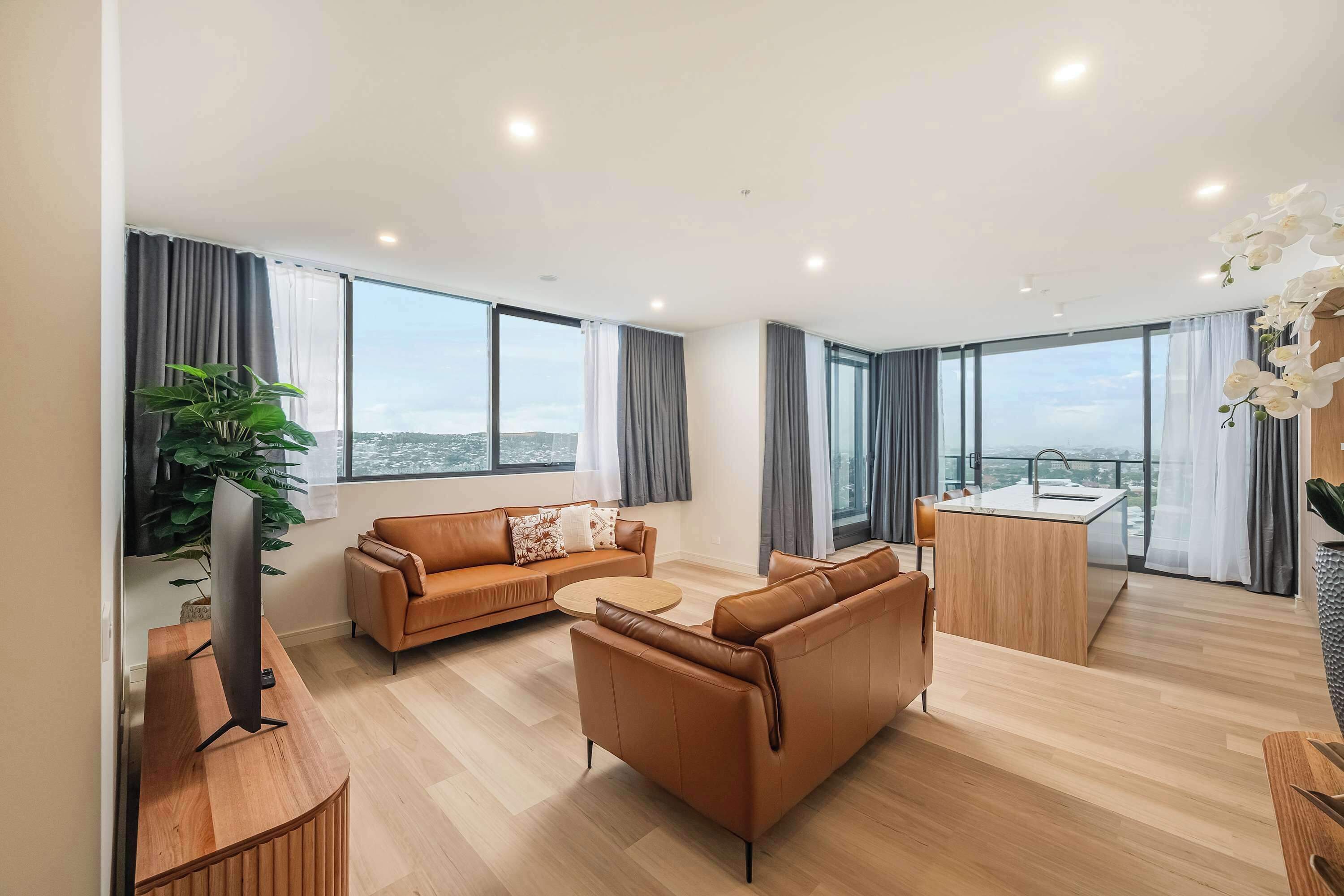 A modern living room with a sofa, coffee table, and a TV on a wooden stand.