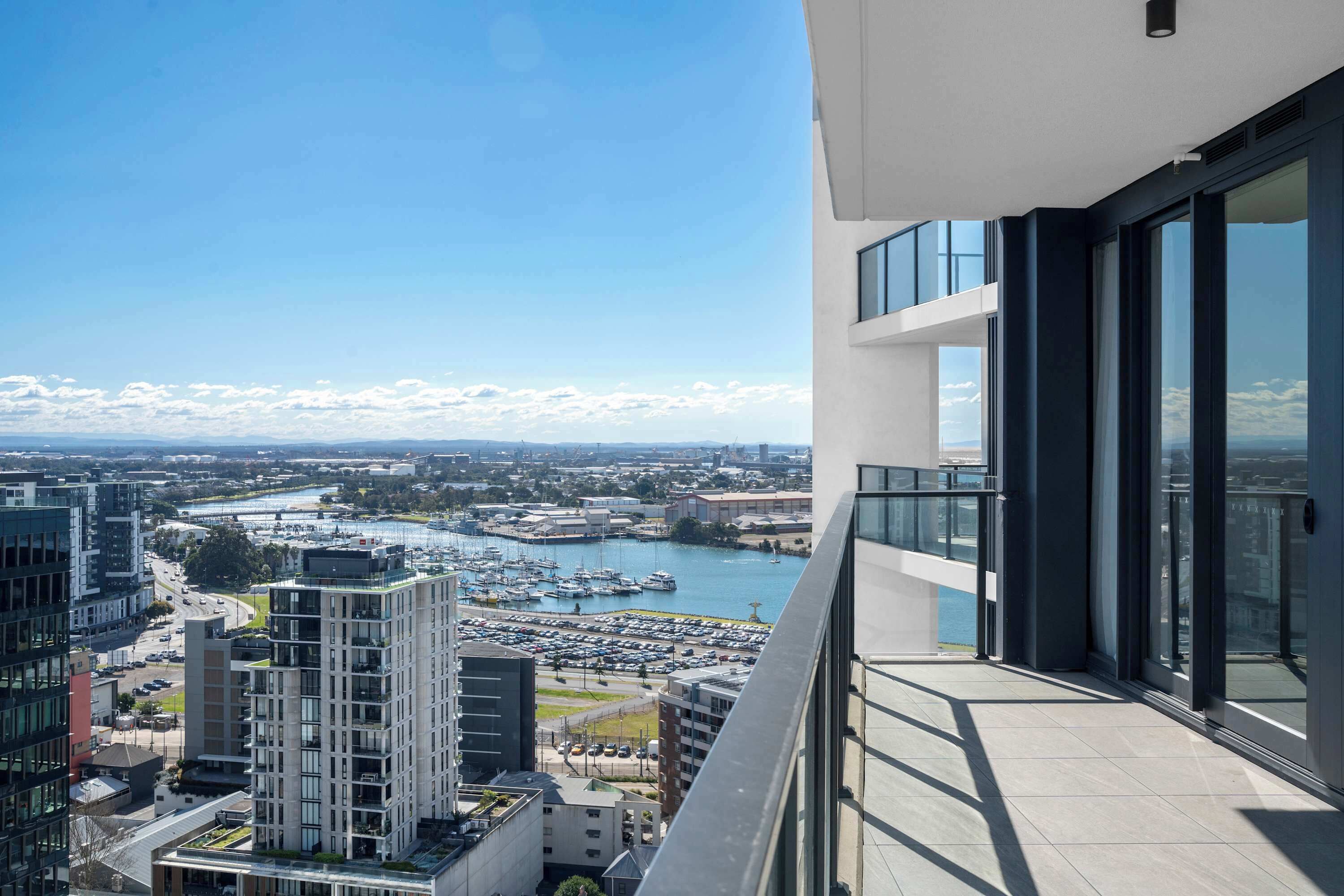 A high-rise building with a view of a marina and cityscape.