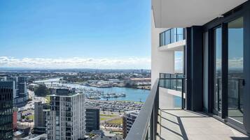 A high-rise building with a view of a marina and cityscape.