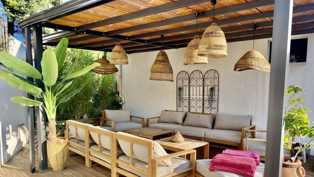 An outdoor seating area with wooden furniture, woven pendant lights, and potted plants. - House 6 persons between vineyards and garrigues (Pouzilhac)
