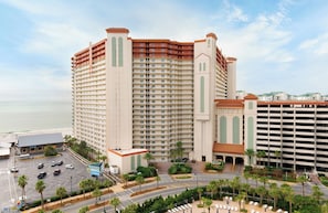Ein Hochhaus-Hotel mit mehreren Etagen, einer Tiefgarage und Blick auf den Strand.