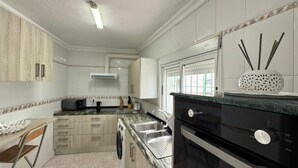 Una cocina con lavadora, estufa y ventana con vistas.